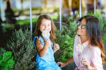 Mom and girl eating candy in the Park
