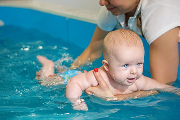 Fototapeta na wymiar Little baby child swimming in pool 