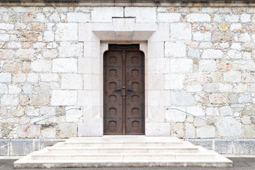 old woden doors in wall of massive stones
