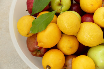 lemon on a leaf, a large amount of natural lemon in a container, yellow lemons,