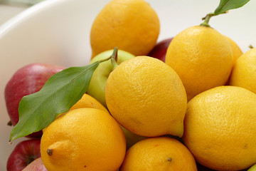 lemon on a leaf, a large amount of natural lemon in a container, yellow lemons,
