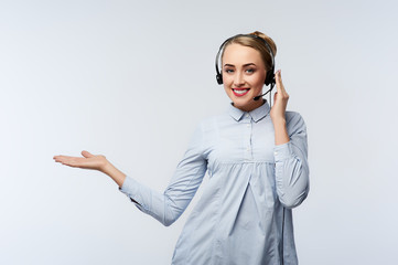 Portrait of cheerful young support phone operator in headset, with copyspace area