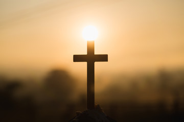 Christian wooden cross on a background with dramatic lighting,  Jesus Christ cross, Easter, resurrection concept. Christianity, Religion copyspace background.