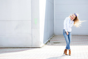 Shapely young woman with long hair dancing outdoor relaxing with smile and eyes closed. Portrait of chilling blonde girl