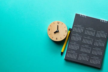 close up of calendar, clock and on the green background, planning for business meeting or travel planning concept