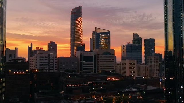 Evening sunset time lapse with the modern city architecture of Abu Dhabi skyline with beautiful clouds, UAE