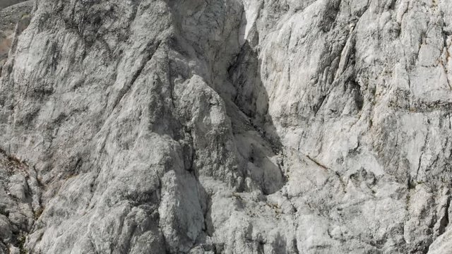Aerial View Panning Over White Rocky Textured Cliff Face