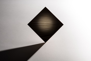 Abstract geometric real wooden cube whit real shadow on white background and it's not 3D render. Lighting technique.