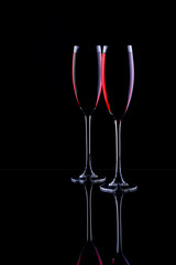 Two glasses with sparkling red wine, on a black background, close-up.