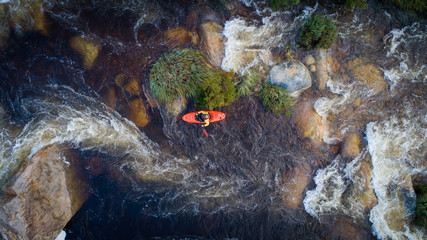 Aerial image of a white water kayaker on a mountain river in flood after good winter rains in south africa - Powered by Adobe
