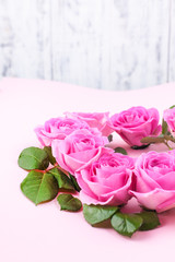 Pink roses on a gentle background. Bouquet as a gift. Card with flowers for the holiday. Free space for text.