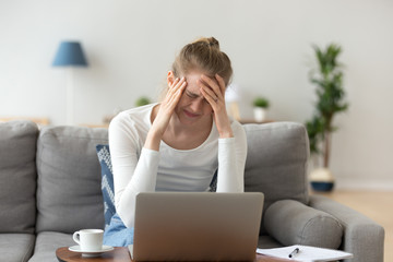 Stressed tired young woman feeling headache after long laptop work 