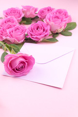 roses and envelope on a light background. Bouquet and letter as a gift in the concept of Valentine's Day or birthday. Free space for text.