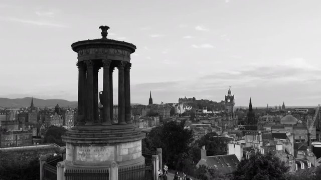 Edinburgh, UK. Calton Hill in Edinburgh, Scotland. Aerial view of the city with Castle and Clock Tower. Time-lapse from day to night, cloudy sky. Illuminated buildings. Black and white