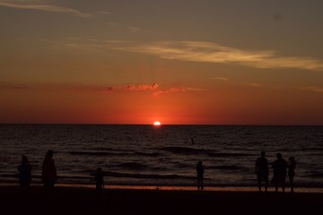 Naklejka na ściany i meble Silhouettes on a Beach at Sunset