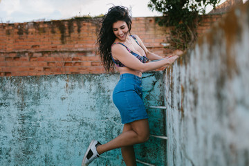 Smiling young brunette woman with bikini in an old empty pool