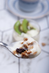 Breakfast homemade yogurt with kiwi and grains in glass served with coffee in the morning