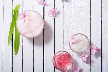 beauty products with hyacinth flowers on white wood