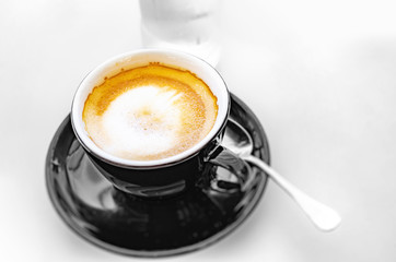 Delicious espresso coffee in a dark cup on the table.