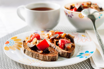 Vegetable stew with eggplant, red pepper and tomatoes on toasted rye bread
