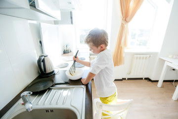 funny European little boy chef dancing,Happy weekend, boy wants to make pancakes, but the frying pan are too gay, he decided to have fun holding wooden spoons in his hands, having fun while cooking