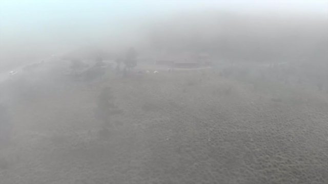 Aerial Forward: Tents and Building on Meadow Among Forest