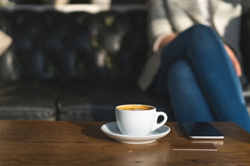 Selective focus on cup of hot beverage, credit card and cellular on table