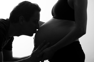 Padre besando la barriga de madre embarazada