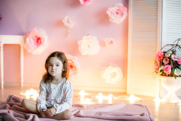 Adorable little girl dressed as a ballerina in a tutu, tying her ballet slippers. © ElenaBatkova