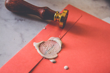 Paper pink envelope with sealing wax stamp and invitation card