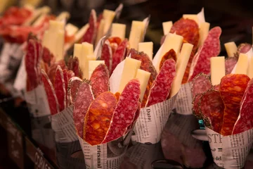 Fototapeten Vorspeise mit Wurst und Käse in einem Bagel aus der Zeitung auf dem Markt Boqueria in Barcelona © Olga Labusova