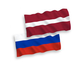 National vector fabric wave flags of Latvia and Russia isolated on white background. 1 to 2 proportion.
