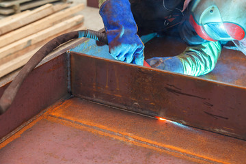 Worker welding in a factory. Welding on an industrial plant