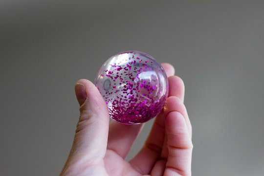 flummi mit pinkem glitter zwischen den fingern