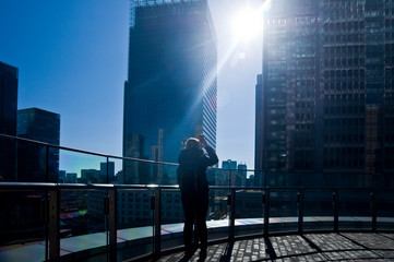 Fototapeta premium Woman photographing modern city with her mobile
