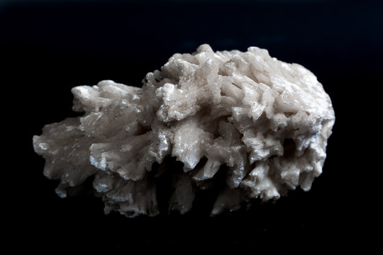Drusus gypsum. white stone on a black background.
