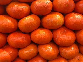 Fresh and natural tangerines background in intense orange in the organic market