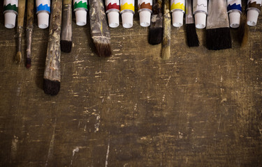 Paints and brushes on the old background