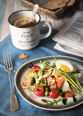 Breakfast. Arugula salad with salmon and parmesan, a cup of tea with lemon. Rustic style. Food photo.