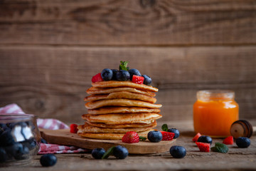 Pancakes with berries and maple syrup and sugar powder