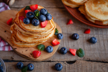 Pancakes with berries and maple syrup and sugar powder