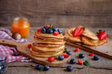 Pancakes with berries and maple syrup and sugar powder