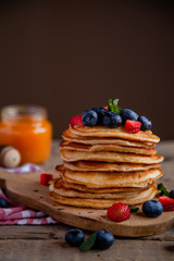 Pancakes with berries and maple syrup and sugar powder