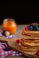 Pancakes with berries and maple syrup and sugar powder