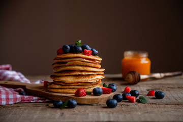 Pancakes with berries and maple syrup and sugar powder