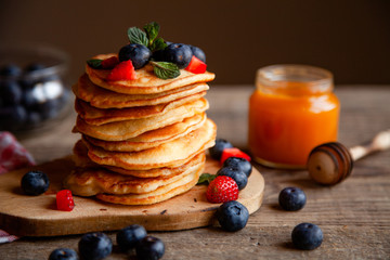 Pancakes with berries and maple syrup and sugar powder