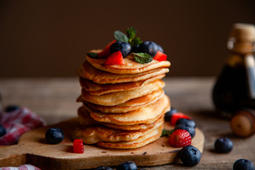 Pancakes with berries and maple syrup and sugar powder