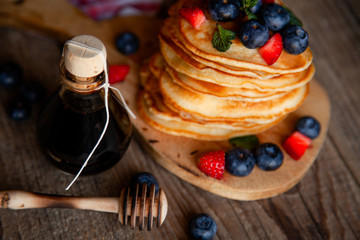 Pancakes with berries and maple syrup and sugar powder