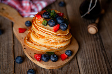 Pancakes with berries and maple syrup and sugar powder