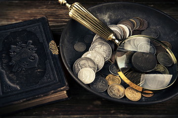 Old moneys and coins through a magnifying glass. Numismatics and collecting money.Russian Empire and world currency.Silver,gold.The Book of Law